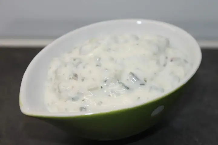 Krämig sås med örter i en grön skål, perfekt till fisk. Kanske skolans fisksås?