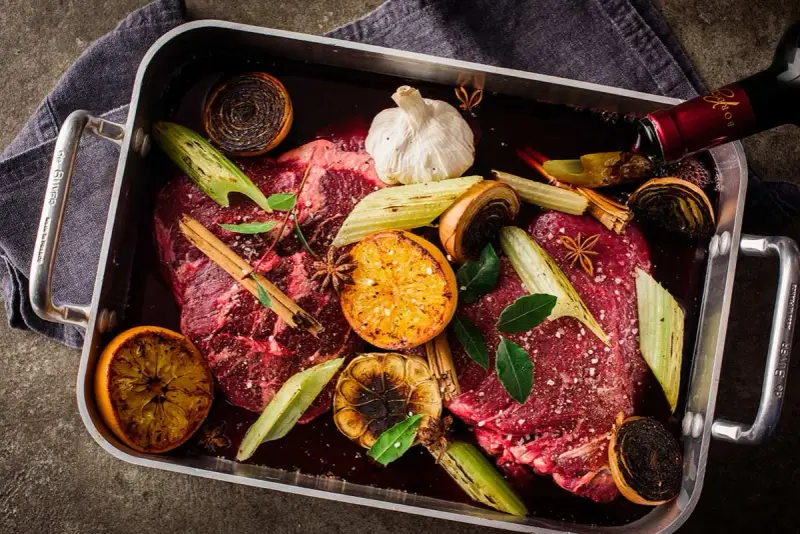 Råstekta köttbitar med apelsin, lök, vitlök och stjärnanis i en form. Ett perfekt minutfile recept för en festmåltid.